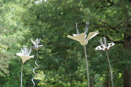 Installation au domaine de Poulaines de 10 fleurs en acier, tissus de verre, r&eacute;sines teint&eacute;es et enjoliveurs transform&eacute;s (Corolles entre 35 et 45 cm de circonf&eacute;rence, tiges de 120 &agrave; 220 cm de hauteur)